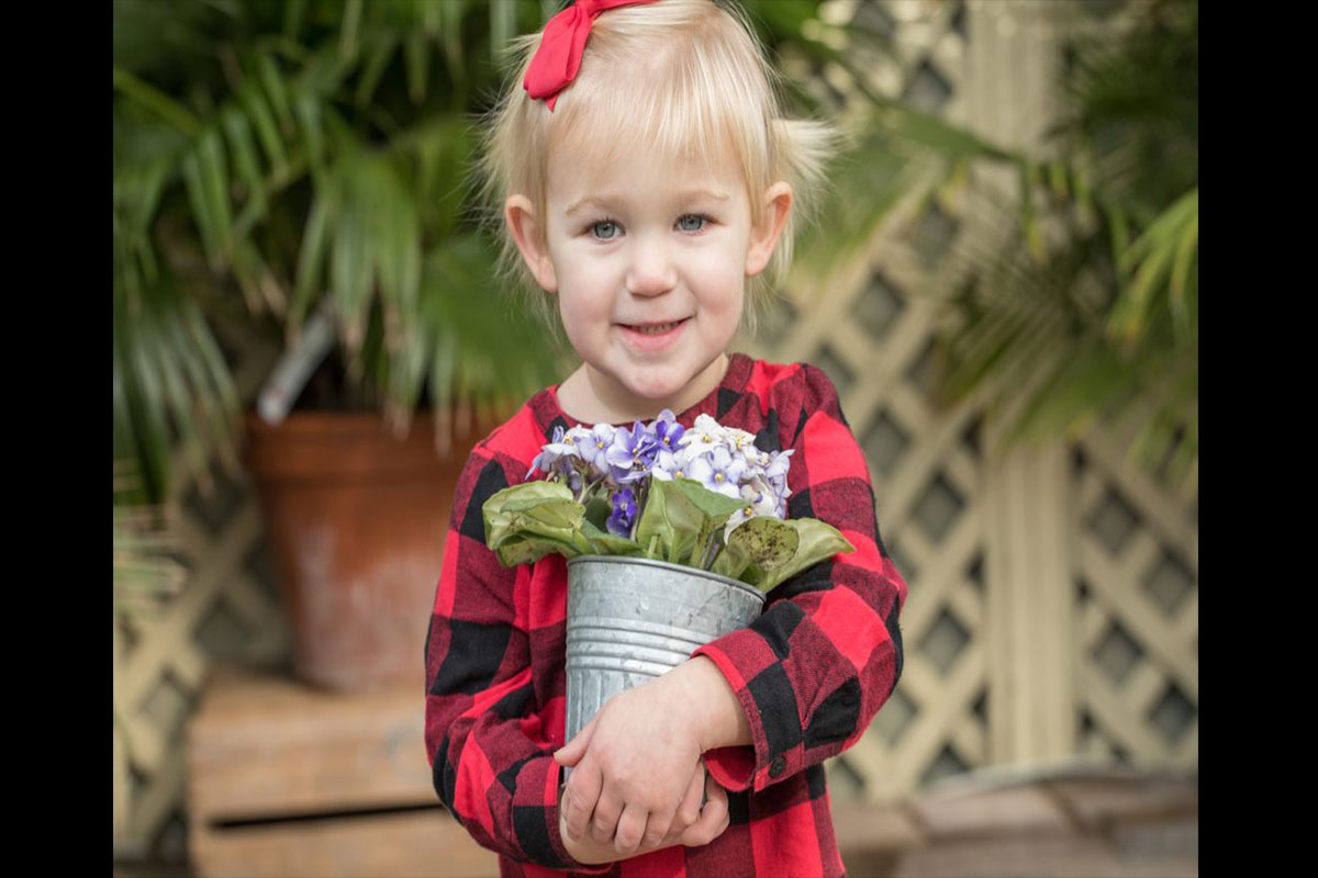 young girl with can of flowers
