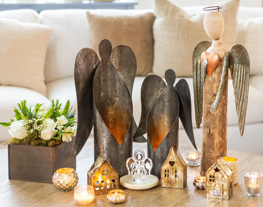 Rustic angel figurines with a lit Christmas village